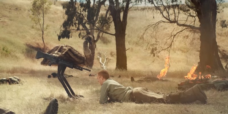 The Emu War movie trailer is the best kind of absurd. An emu aims a gun at a man laying prone on the ground.