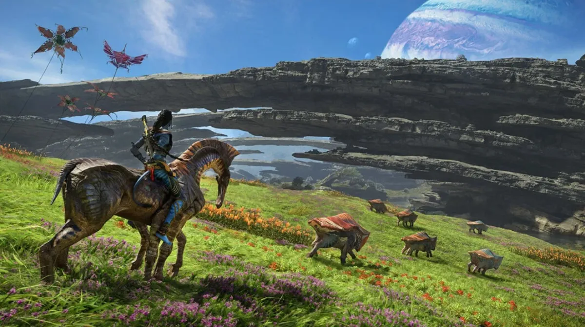 Image from Avatar: Frontiers of Pandora as part of a preview of the upcoming Ubisoft game. In the image, a Navi rides an animal while looking at a bunch of other animals. A moon or planet is visible in the background above a stone arch.