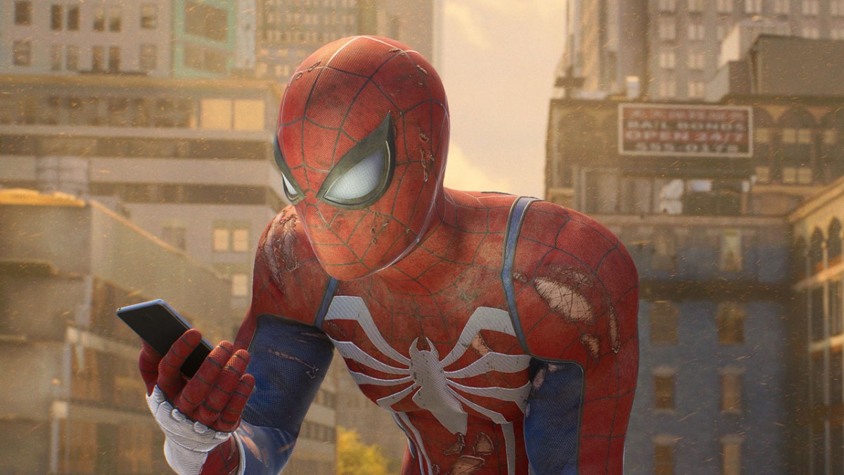 Spider-Man in Marvel's Spider-Man 2, looking at his phone. He's probably reading our ranking of the game's villains.