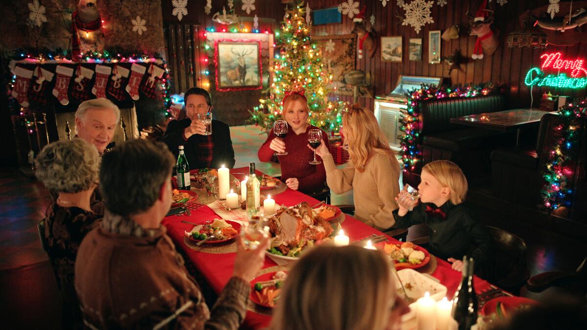 Characters sitting and having a Christmas meal. This image is part of an article about when Virgin River Season 6 comes out.