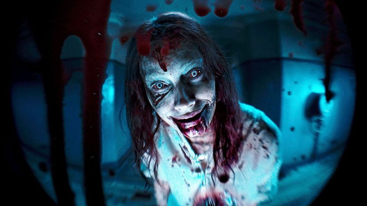 A Deadite looking through a peep hole. This image is part of an article about the best horror movies of 2023.