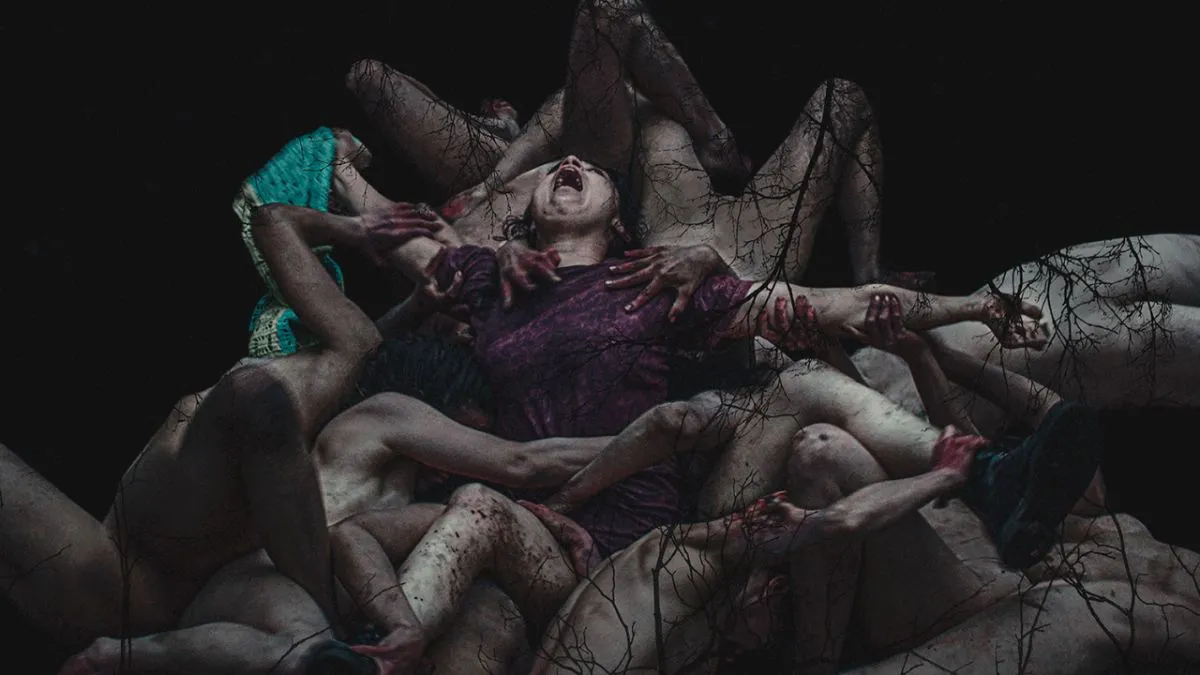 A woman covered in bodies. This image is part of an article about the best horror movies of 2023.