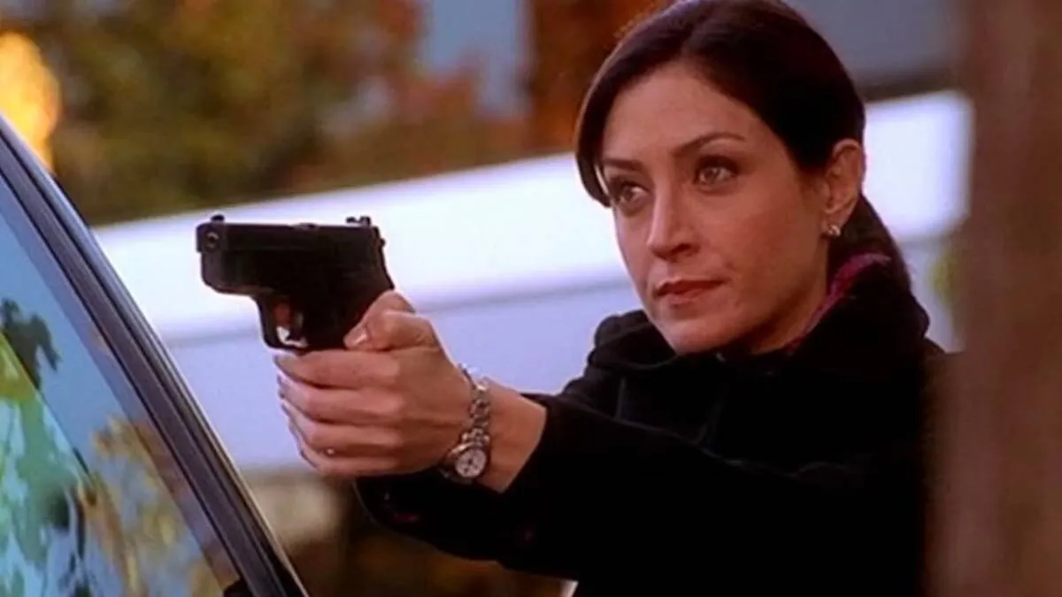 Kate holding a gun in NCIS. This image is part of an article about why Kate actor Sasha Alexander left NCIS.