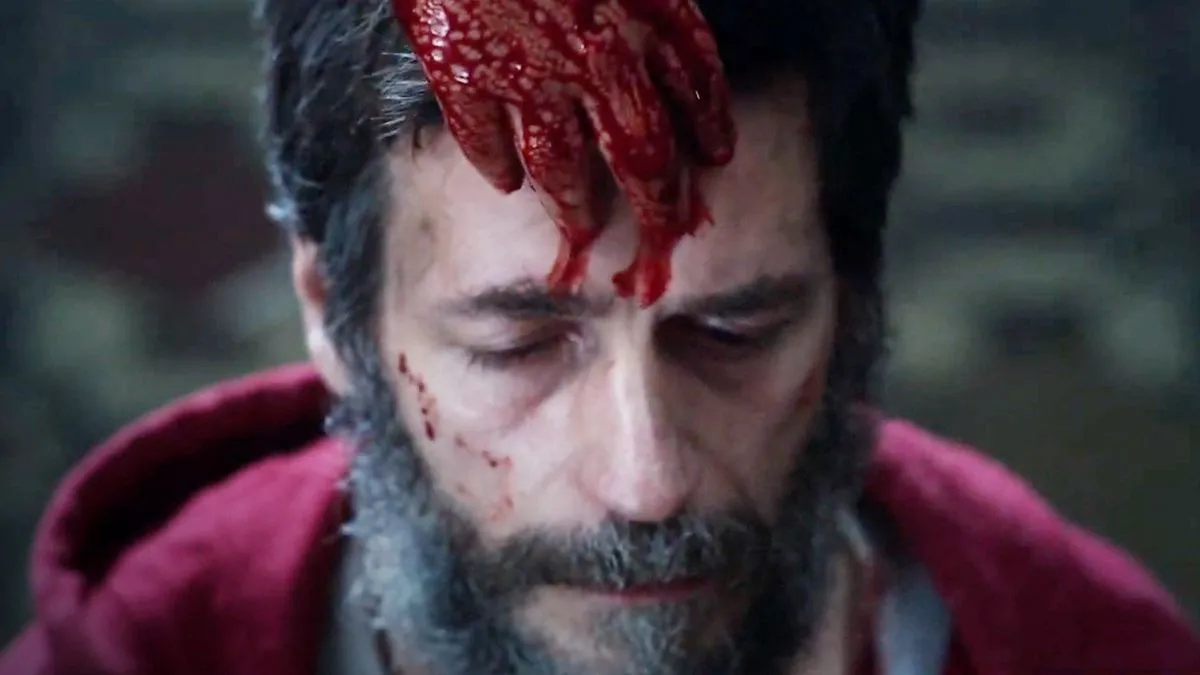 A man with blood on his head. This image is part of an article about the best horror movies of 2023.
