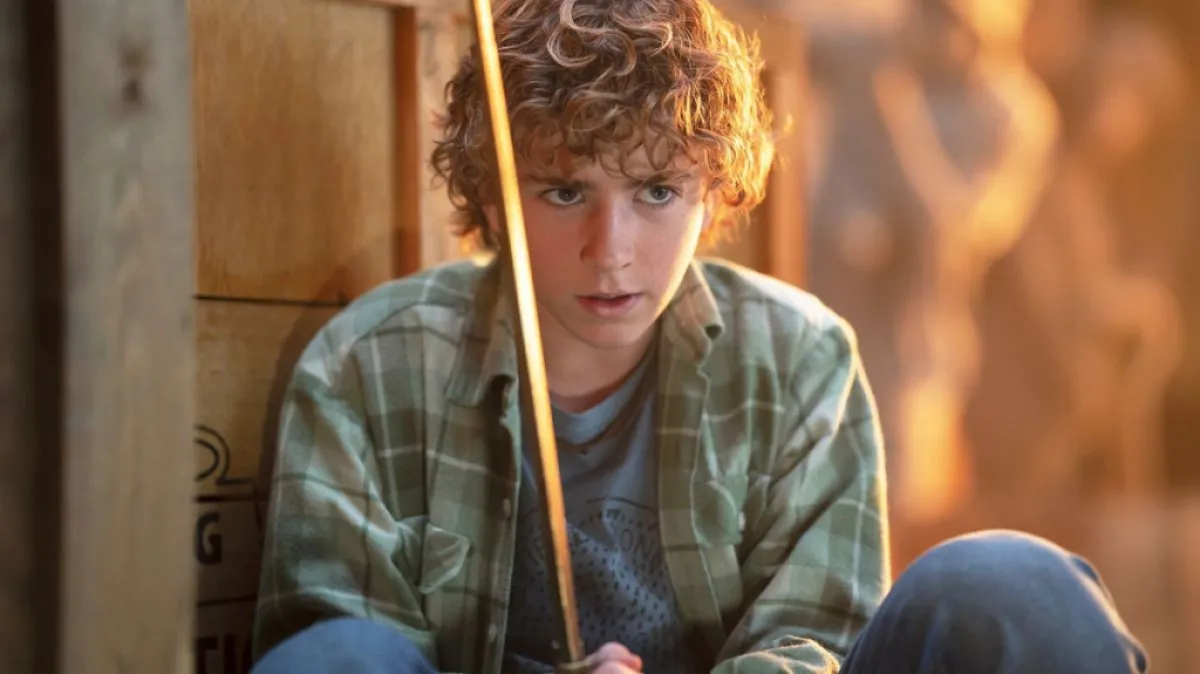 Walker Scobell as Percy Jackson in Percy Jackson and the Olympians as part of an article on the major actors and cast list for the show. The image shows Percy holding his sword.