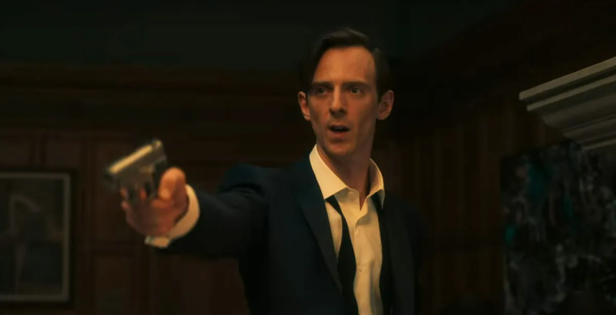 A man in a tuxedo pointing a gun at someone. This image is part of an article about Netflix's Fool Me Once's ending, explained. 