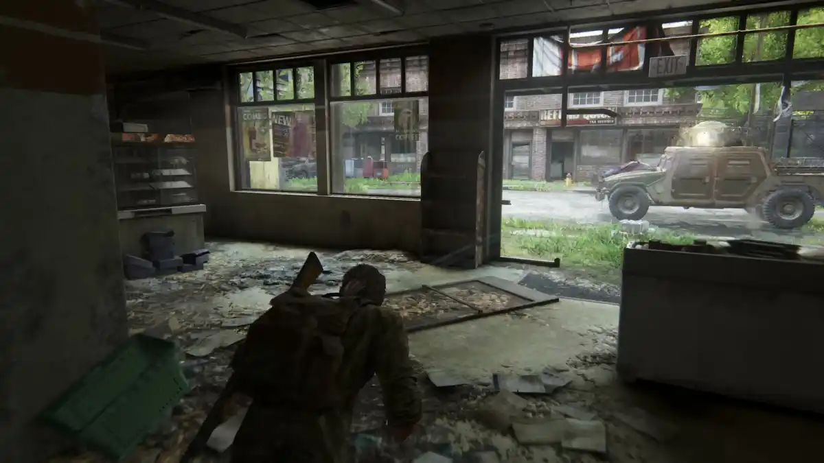 The Last of Us, with Joel, a man in a flannel shirt, creeping towards an armored car.