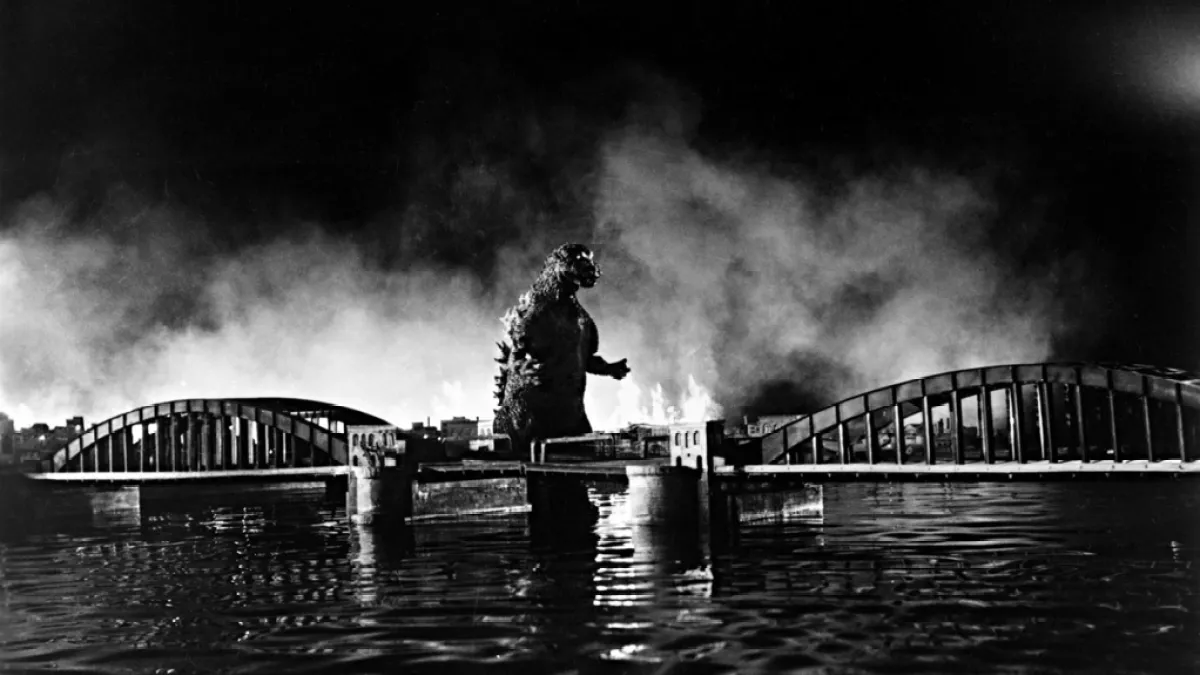 Godzilla walks away from a burning city