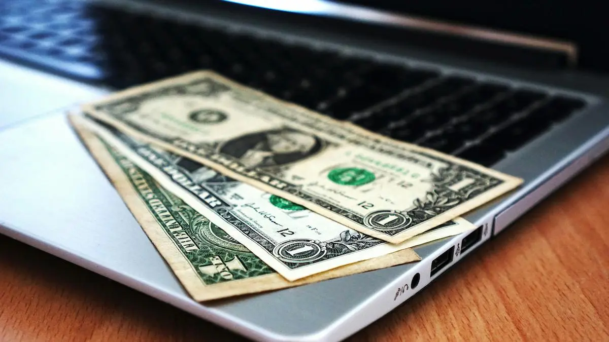 Dollar bills on laptop