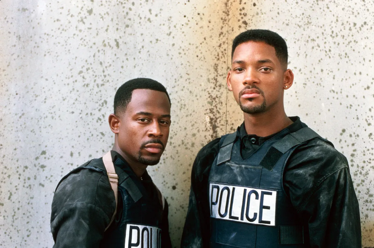 Will Smith and Martin Lawerence standing in front of a wall with serious expressions on their faces.
