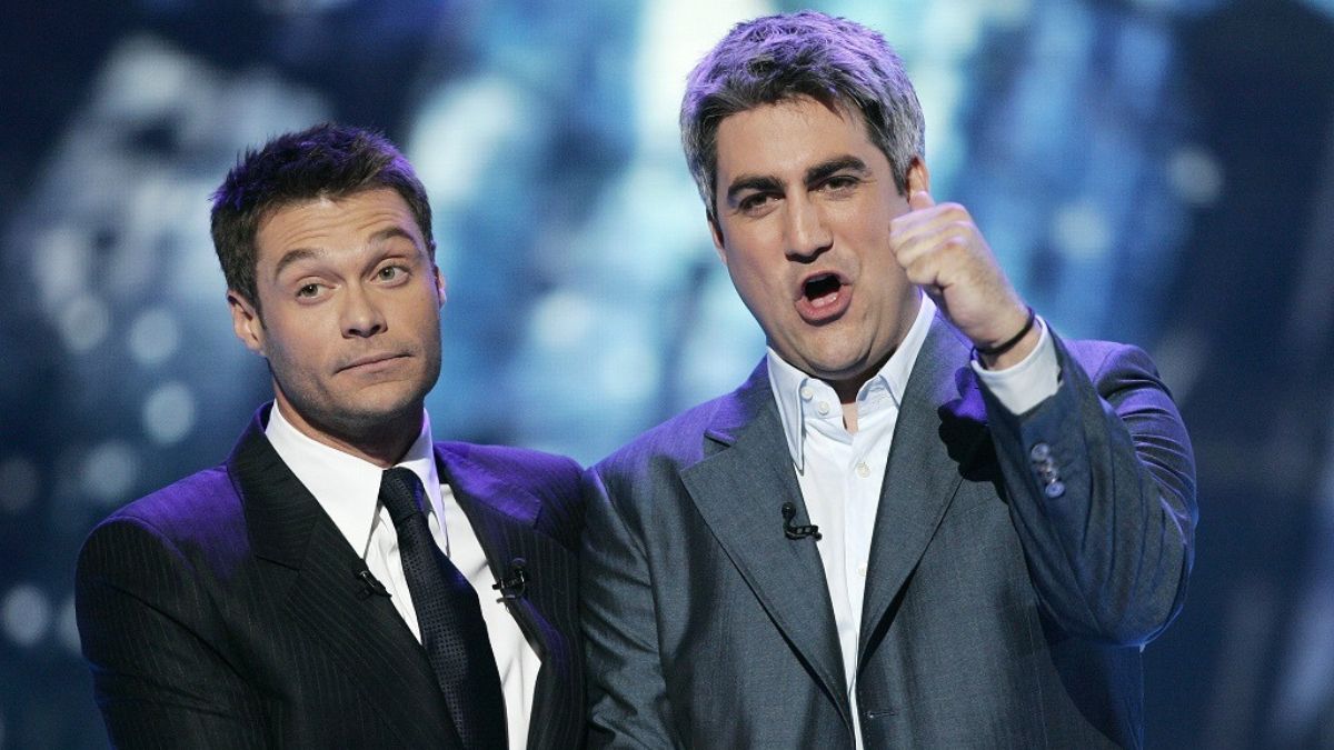 Taylor Hicks giving a thumbs up to the camera next to Ryan Seacrest