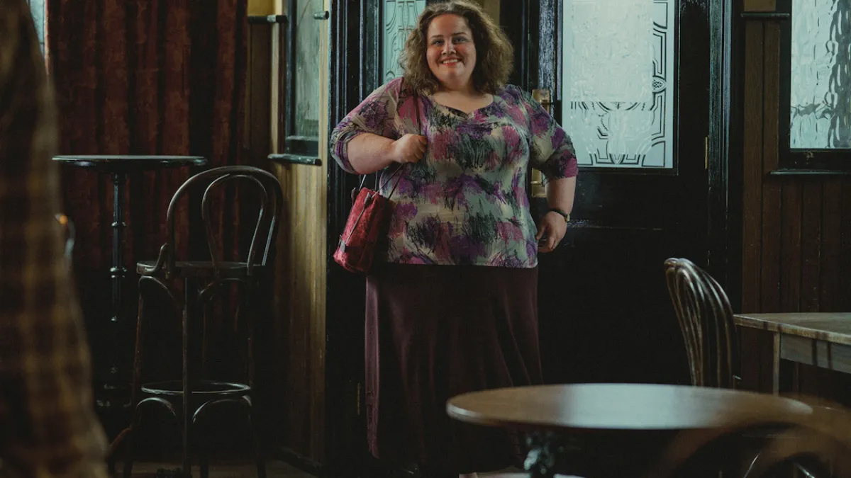 A woman in a dress and handbag walking into a pub in Baby Reindeer smiling.