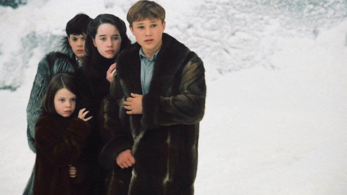 Four children in fur coats in Chronicles of Narnia: The Lion, the Witch and the Wardrobe, huddling in the snow. 