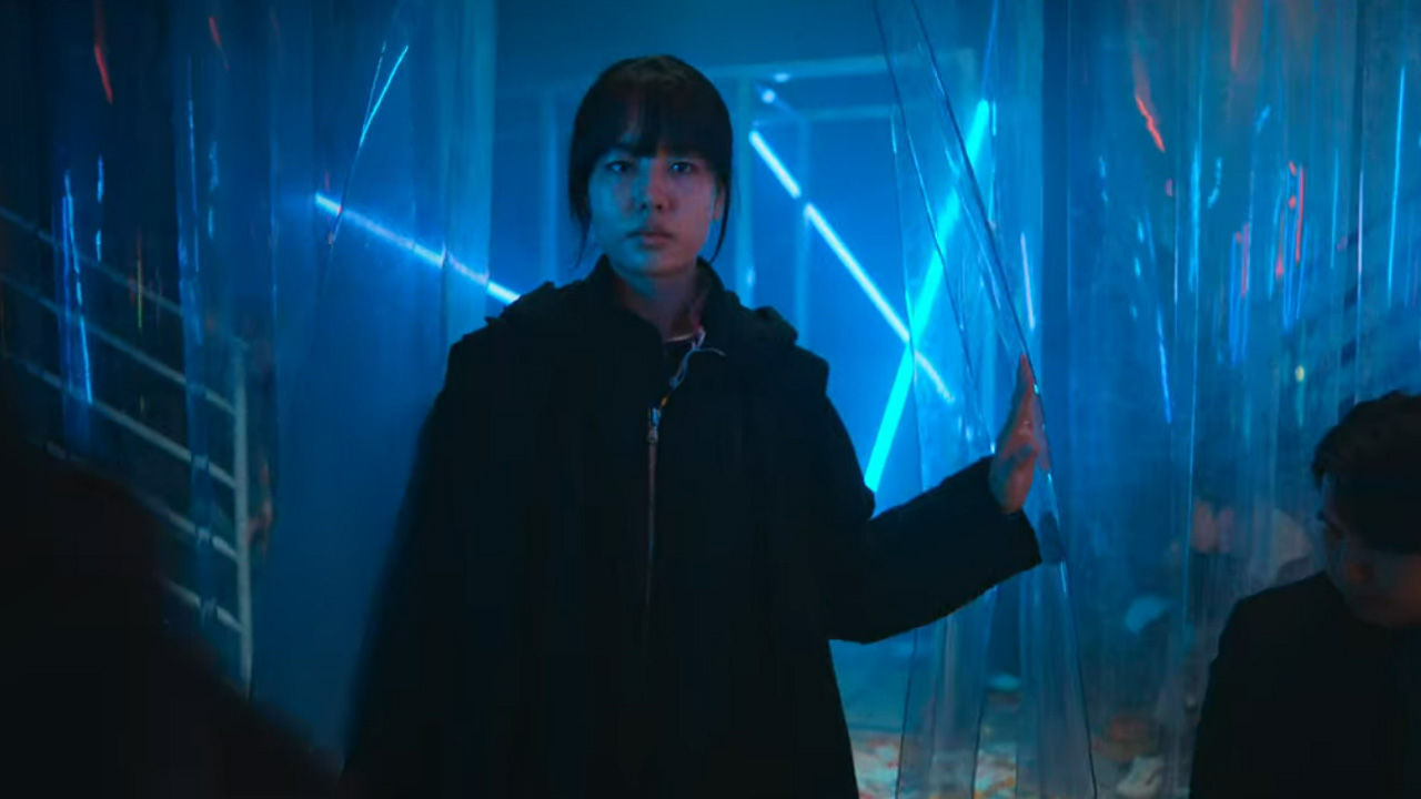 A woman pushing her way through a curtain in a dimly lit club in Goodbye Earth