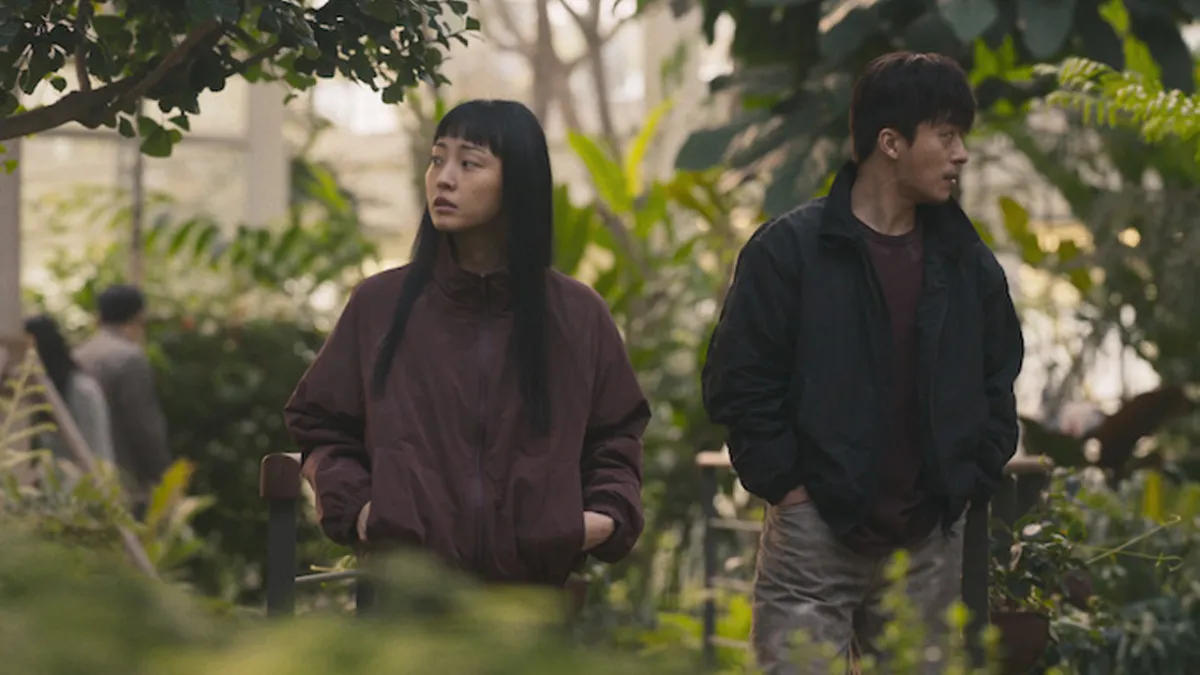 Parasyte: The Grey, a man and a woman walking through a greenhouse. 