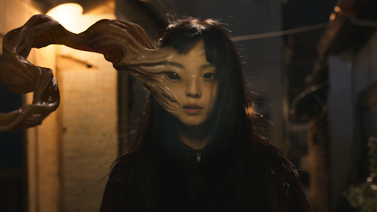 Parasyte: The Grey, with the right hand side of a woman's face stretching out. This image is part of an article about is Parasyte: The Grey getting a Season 2.