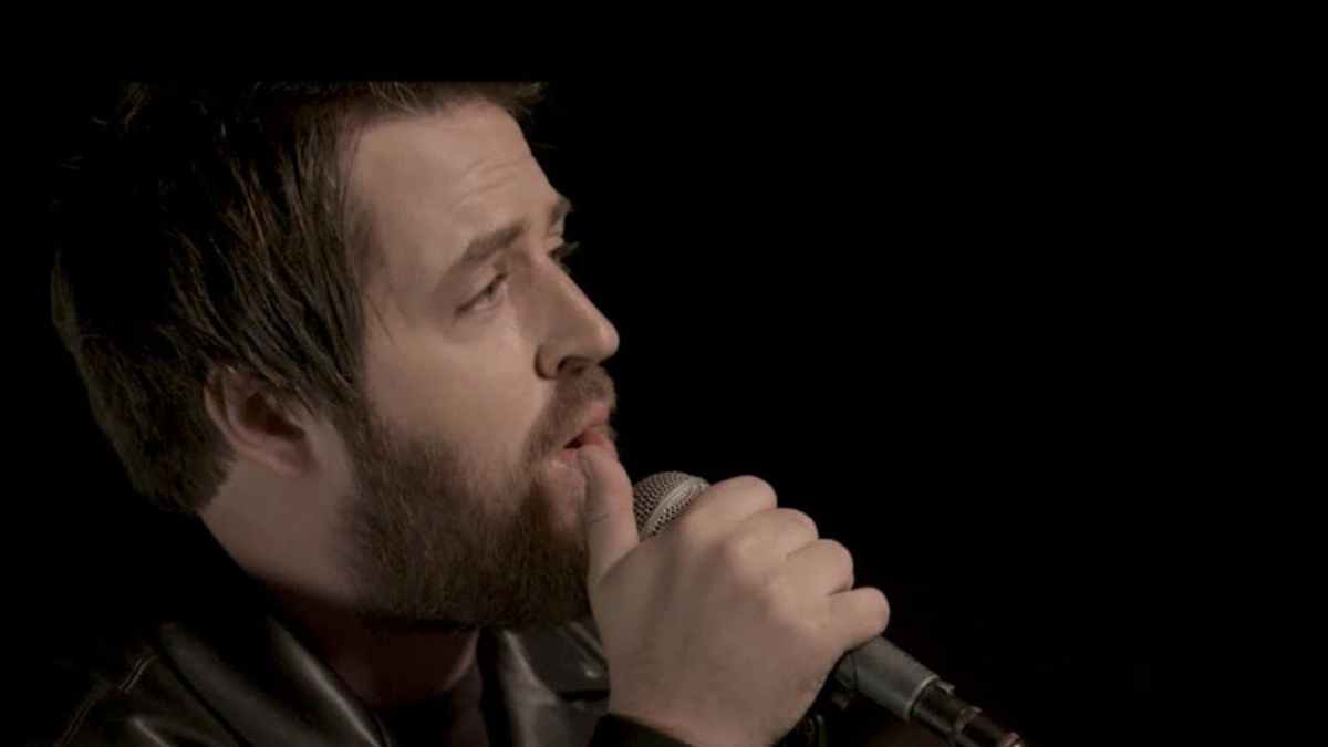 Lee DeWyze singing into a microphone. 