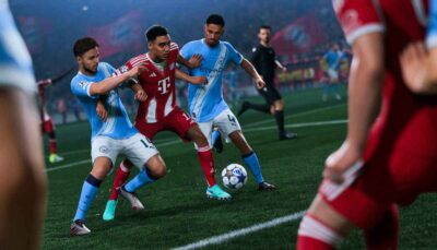 Two players in light blue shirts defend against a player in a red Bayern Munich jersey, as others move in the background on a soccer field.