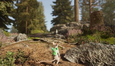 A small mouse from Hela with a green backpack stands on a forest path surrounded by rocks and wildflowers