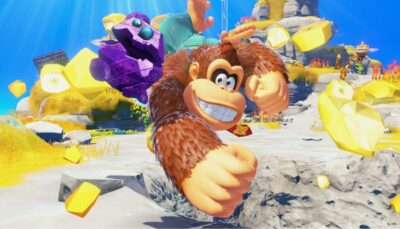 Donkey Kong punching through golden gems in a vibrant, colorful island setting.