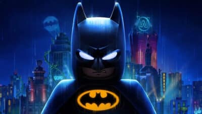Lego Batman standing in Gotham with glowing bat symbol and bat signal in the sky