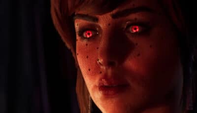 Close-up of a woman with glowing red eyes and dotted facial markings