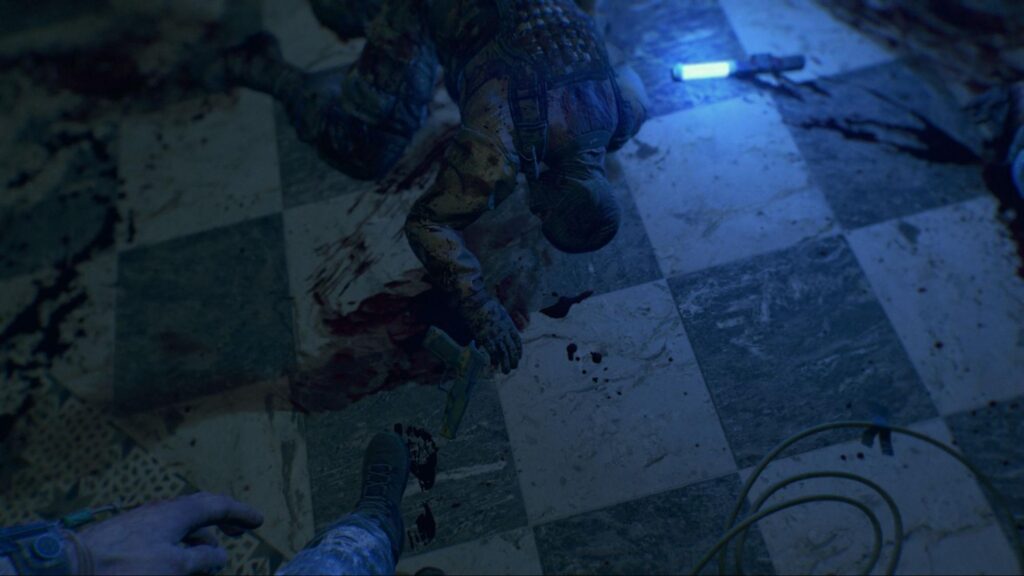 Soldier on bloodstained floor with gun nearby