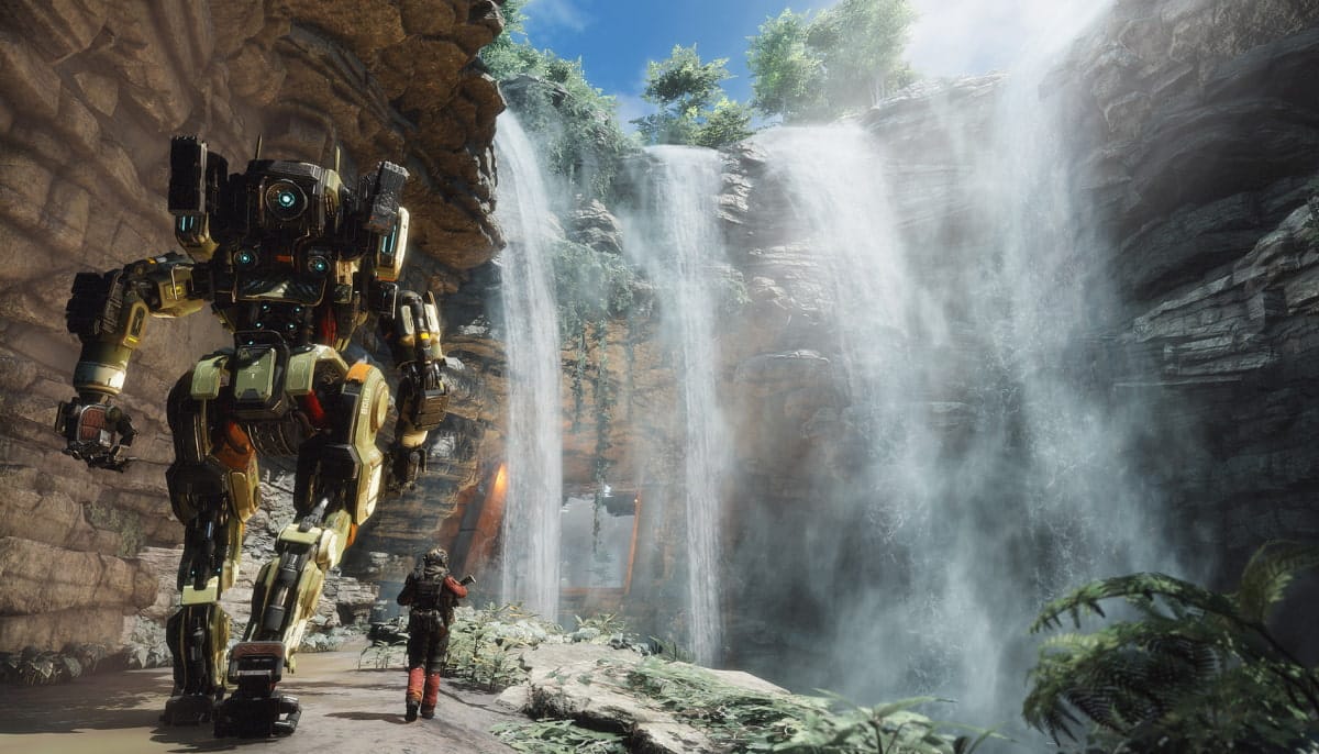 Pilot walking beside Titan mech near towering waterfalls in lush canyon