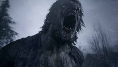 A terrifying werewolf-like monster roaring in the snow during a Resident Evil Village scene