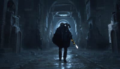 A lone armored figure walks through a dark stone corridor in Hell Is Us, holding a glowing blade as eerie blue light fills the ancient ruins