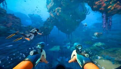 A first-person view in Subnautica 2 showing the player using dual underwater propulsion tools while swimming alongside another diver through a vibrant ocean biome filled with coral formations and alien fish