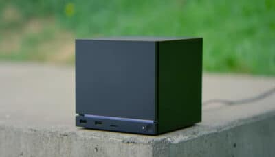 Valve's Steam Machine sits on a concrete surface, surrounded by greenery