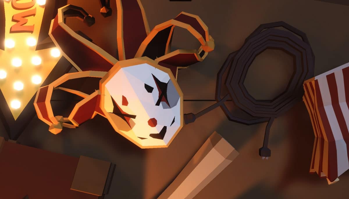 A jester-style mask from This Ain’t Even Poker, Ya Joker lying on a cluttered tabletop with ropes and circus-themed props around it