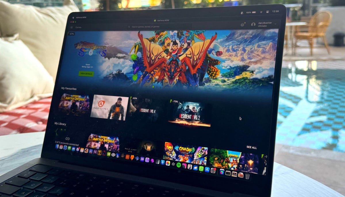 A laptop displays a game library interface while using Nvidia’s GeForce NOW by a poolside setting