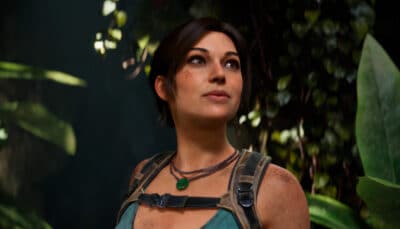 Lara Croft looks upward while standing among dense jungle foliage in Tomb Raider