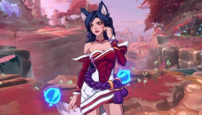 Ahri poses calmly among red foliage and rocky cliffs in a stylized environment from 2XKO