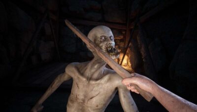 First-person view in Decrepit showing the unnamed prisoner holding a sword and magic staff while facing a grotesque undead creature pushing a wooden wheel in a dark medieval courtyard.