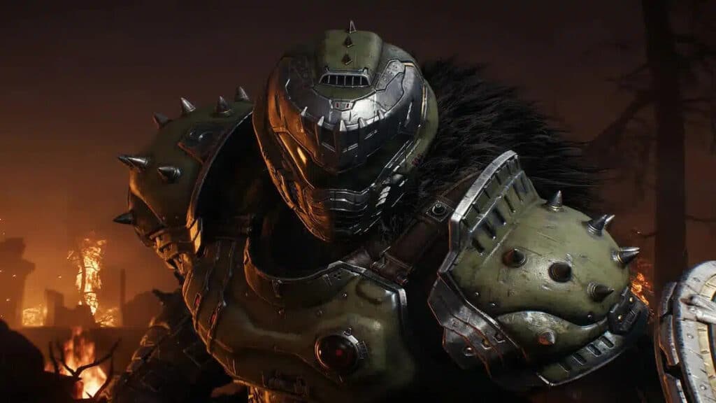 『Doom The Dark Ages』で、重装のドゥームスレイヤーが炎と廃墟の中に立っている