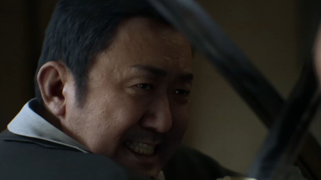 A furious man in Gang of Dragon bares his teeth as he raises his arm during a violent moment