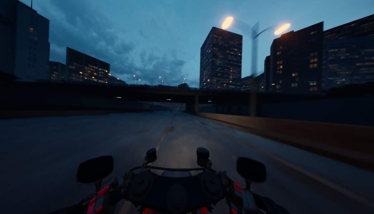 A motorcycle stands still on a wet road with dark skyscrapers looming ahead in Lanesplit