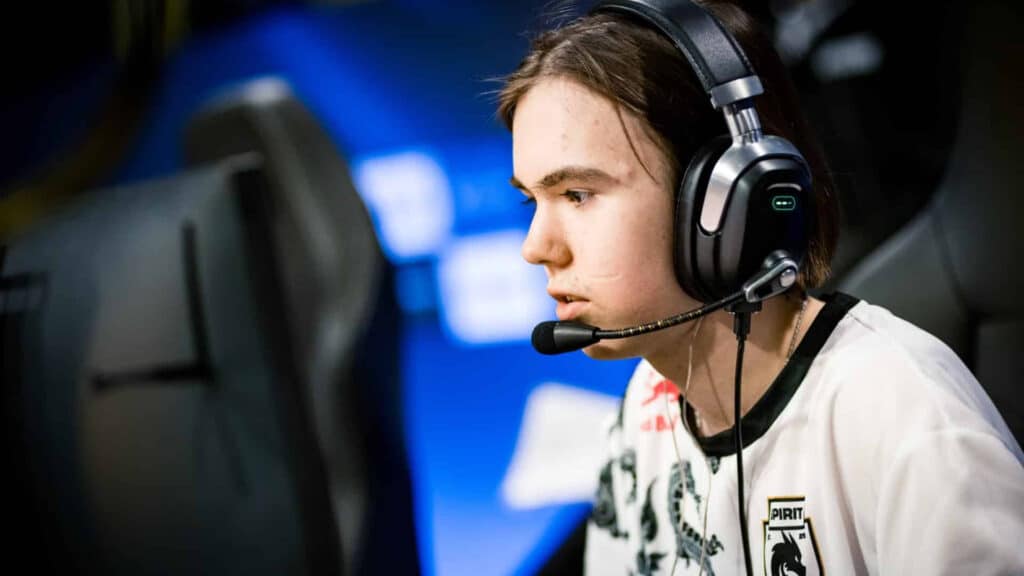 A focused esports player wears a headset while competing on stage during CS2 tournaments