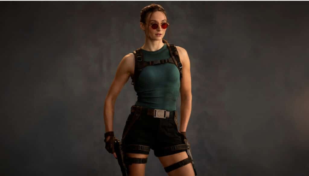 Lara Croft stands in a studio pose wearing tactical gear in a modern Tomb Raider render