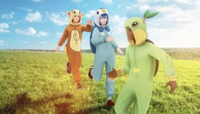 Pokémon GO trainers run across a grassy field while wearing colorful Pokémon themed onesies