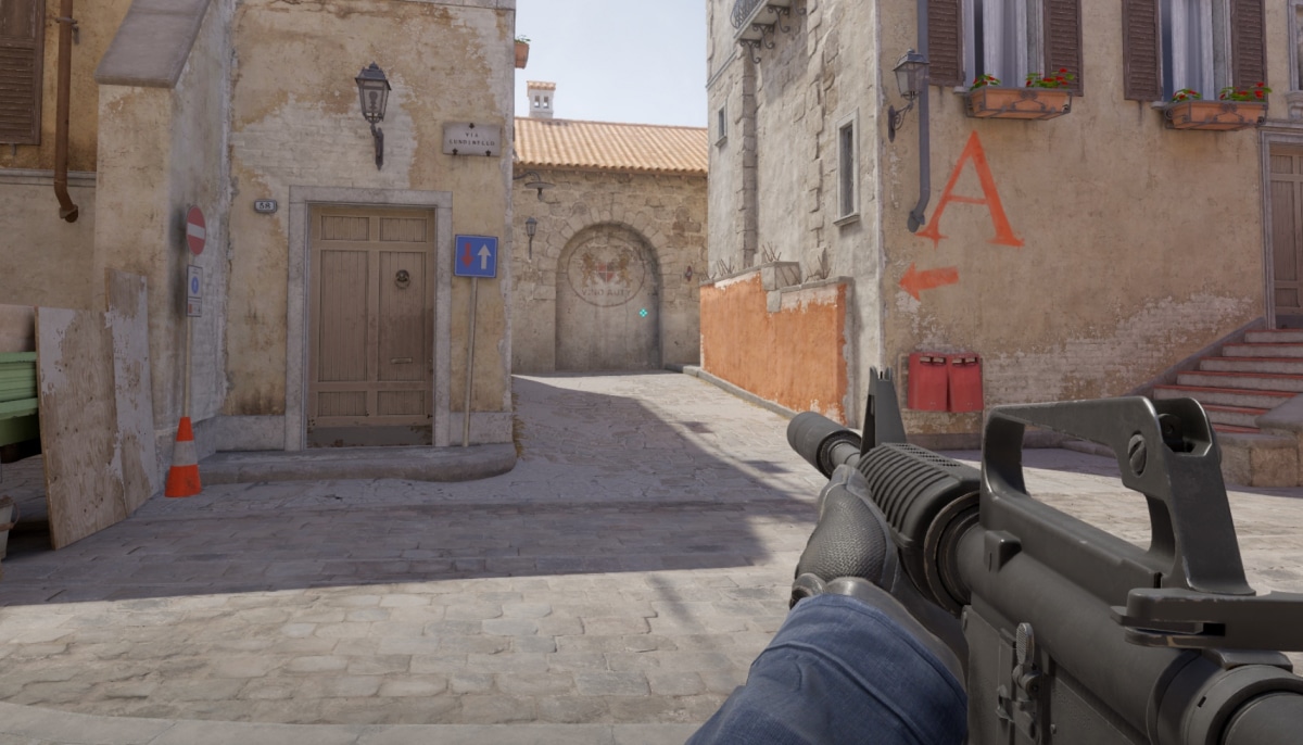 Counter-Strike 2 first-person view aiming down a narrow street toward the A site
