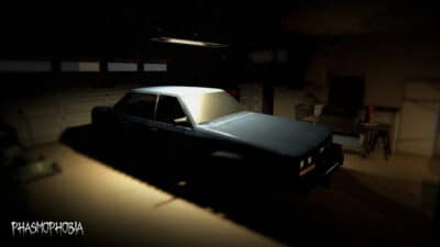 Dark garage interior with vintage car in Phasmophobia's Tanglewood Drive rework