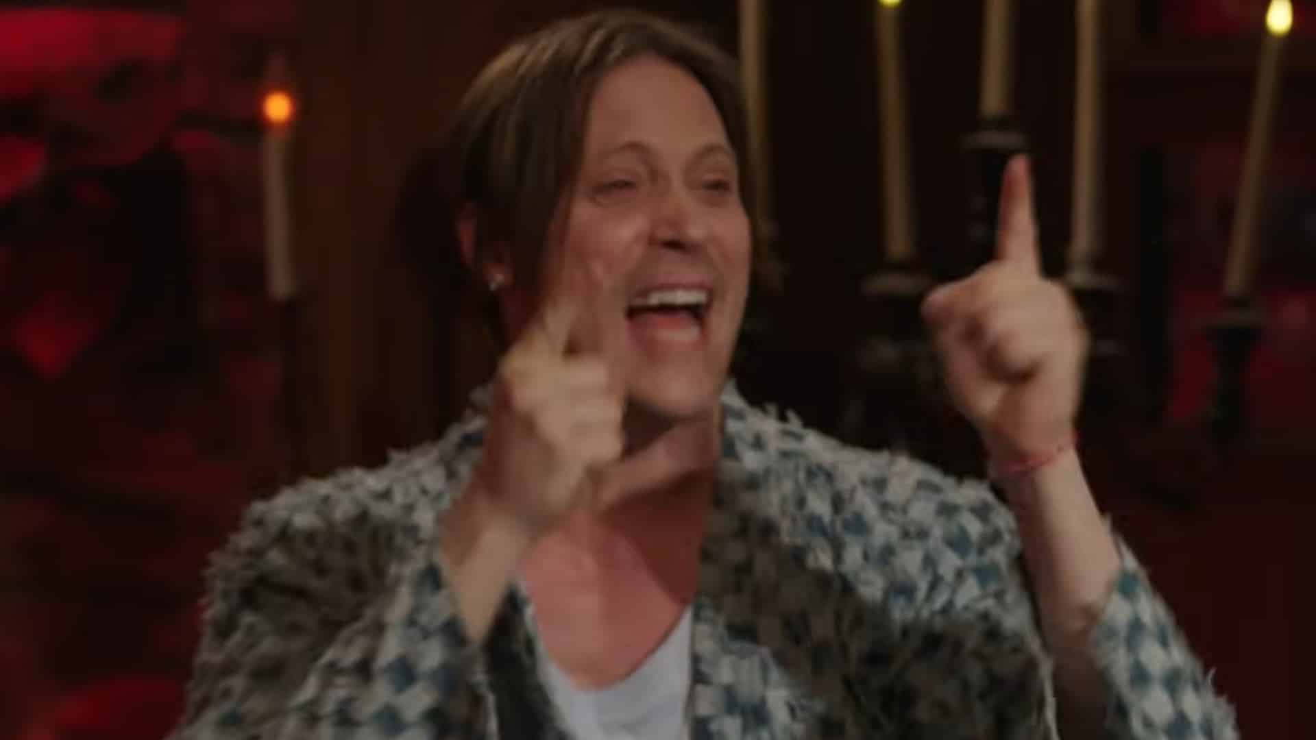 Neil Newbon pointing his fingers in excitement at a DnD table.