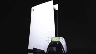 Picture of a PS5 and controller, with the UK Green party logo on the controller