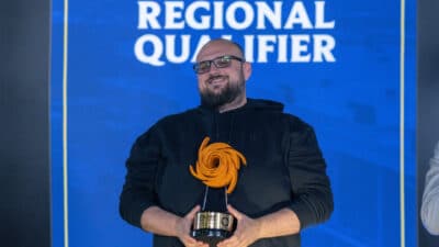 AlanZQ, the winner of Riftbound Vancouver RQ, holding his trophy